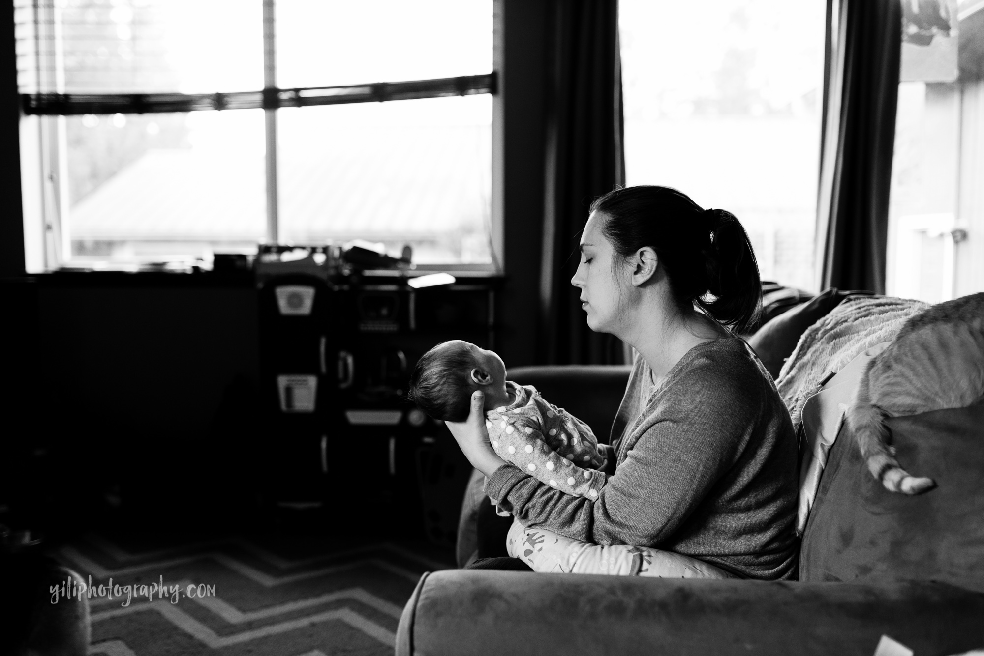 black and white photo of seattle mom with newborn on couch