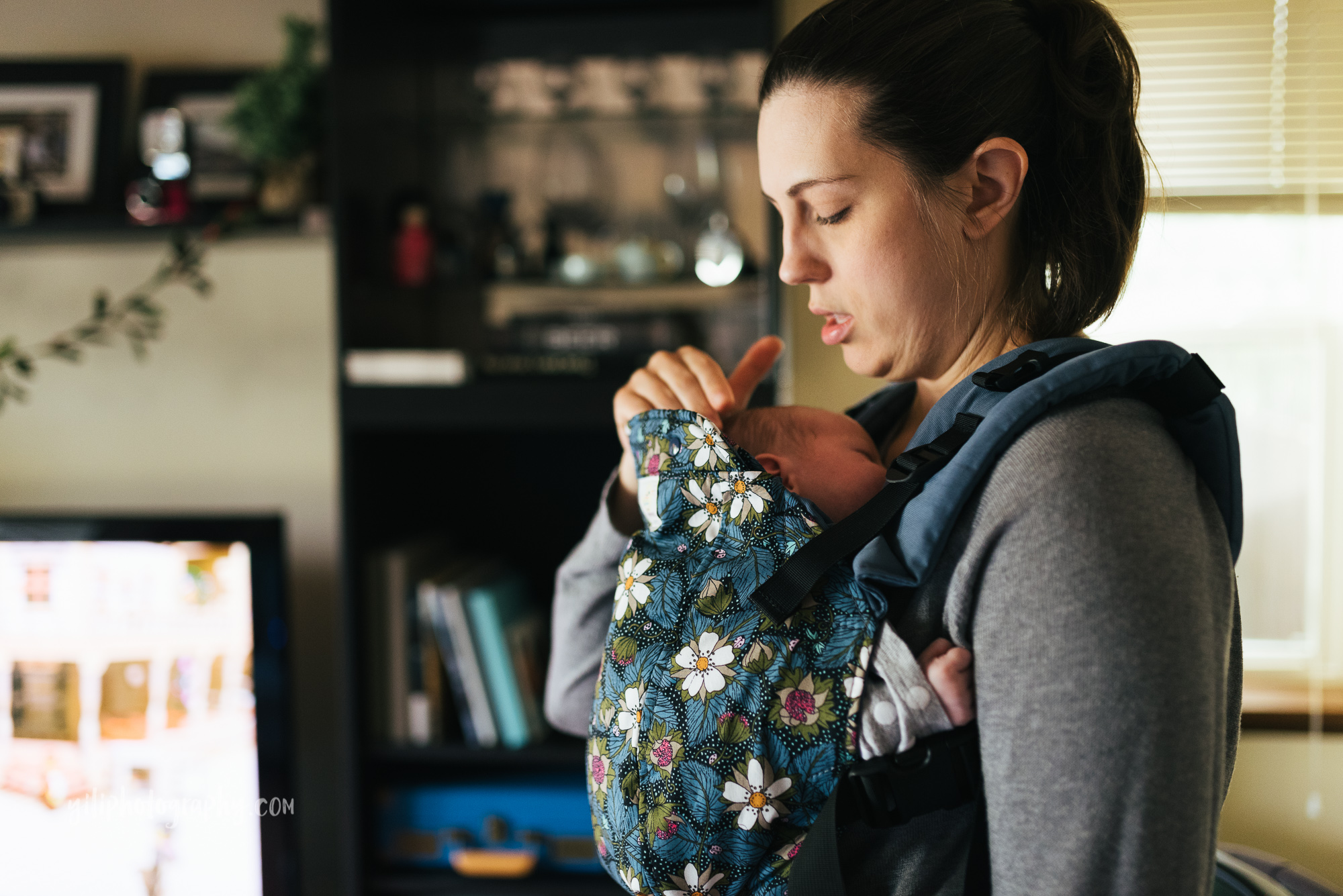 seattle mom adjusting newborn baby in baby carrier