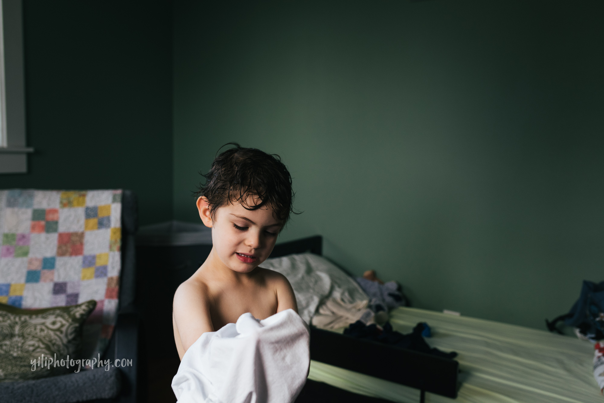 seattle little boy getting dressed in bedroom