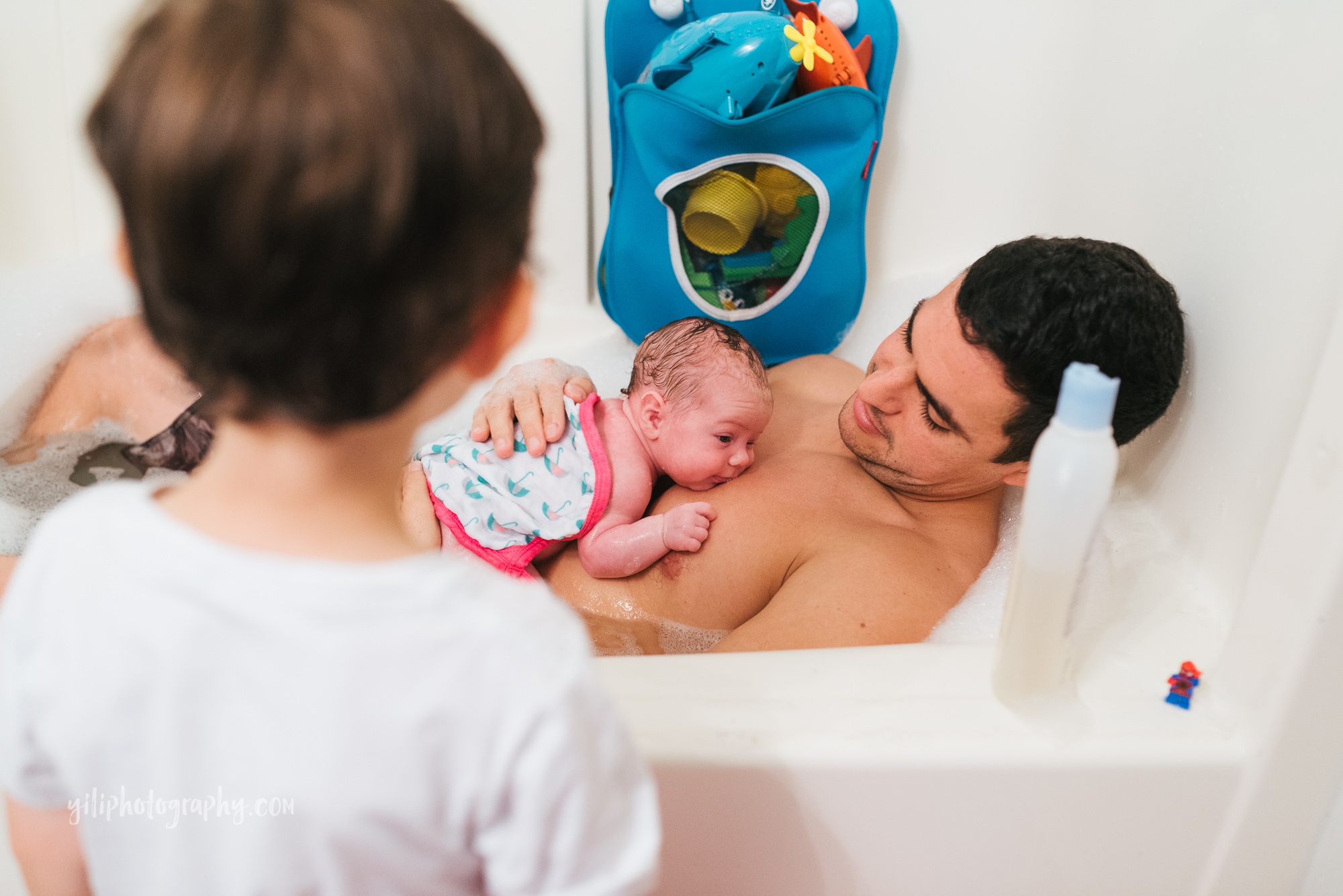 seattle newborn baby lying on dad's chest in bathtub