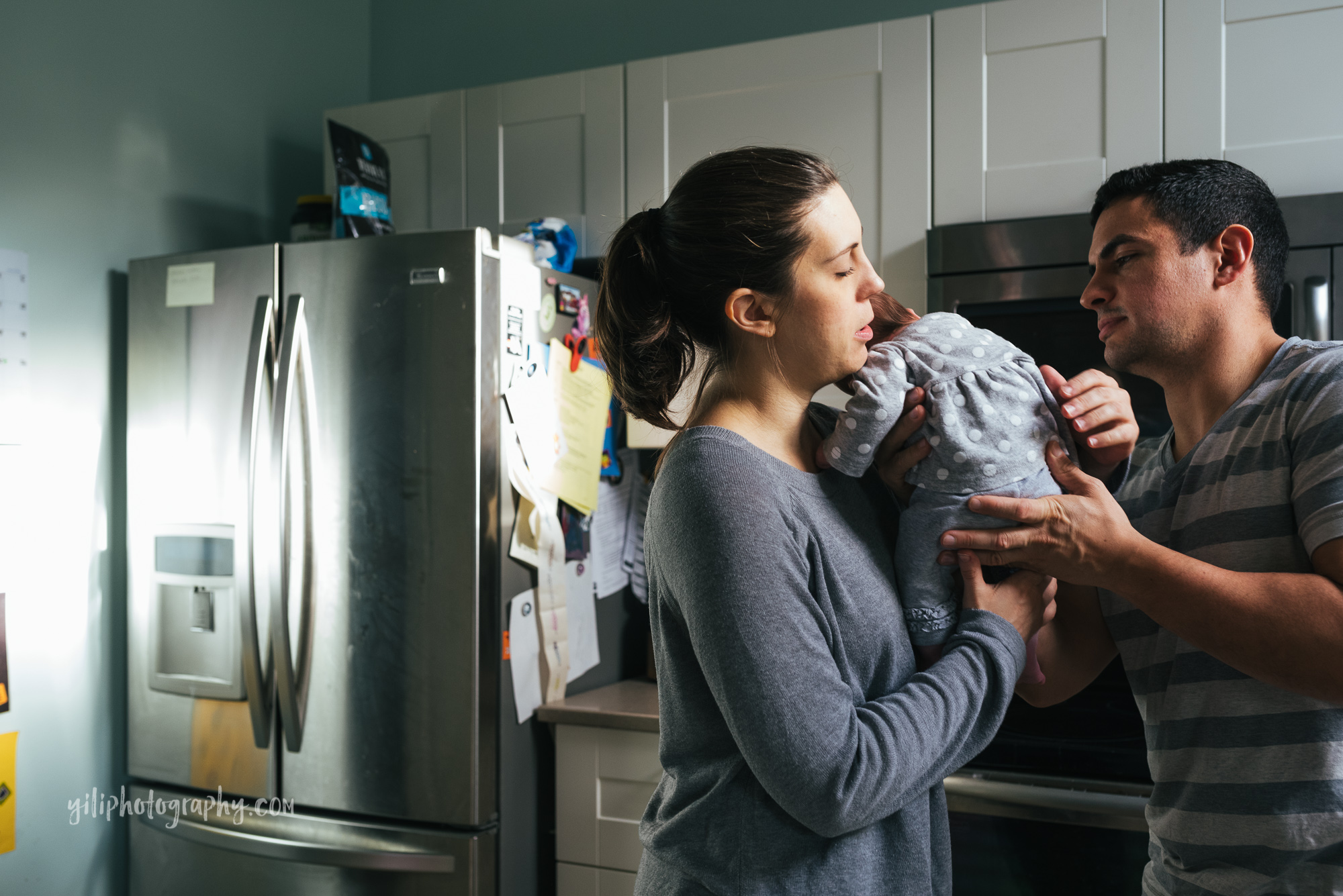 seattle mom handing newborn baby to dad