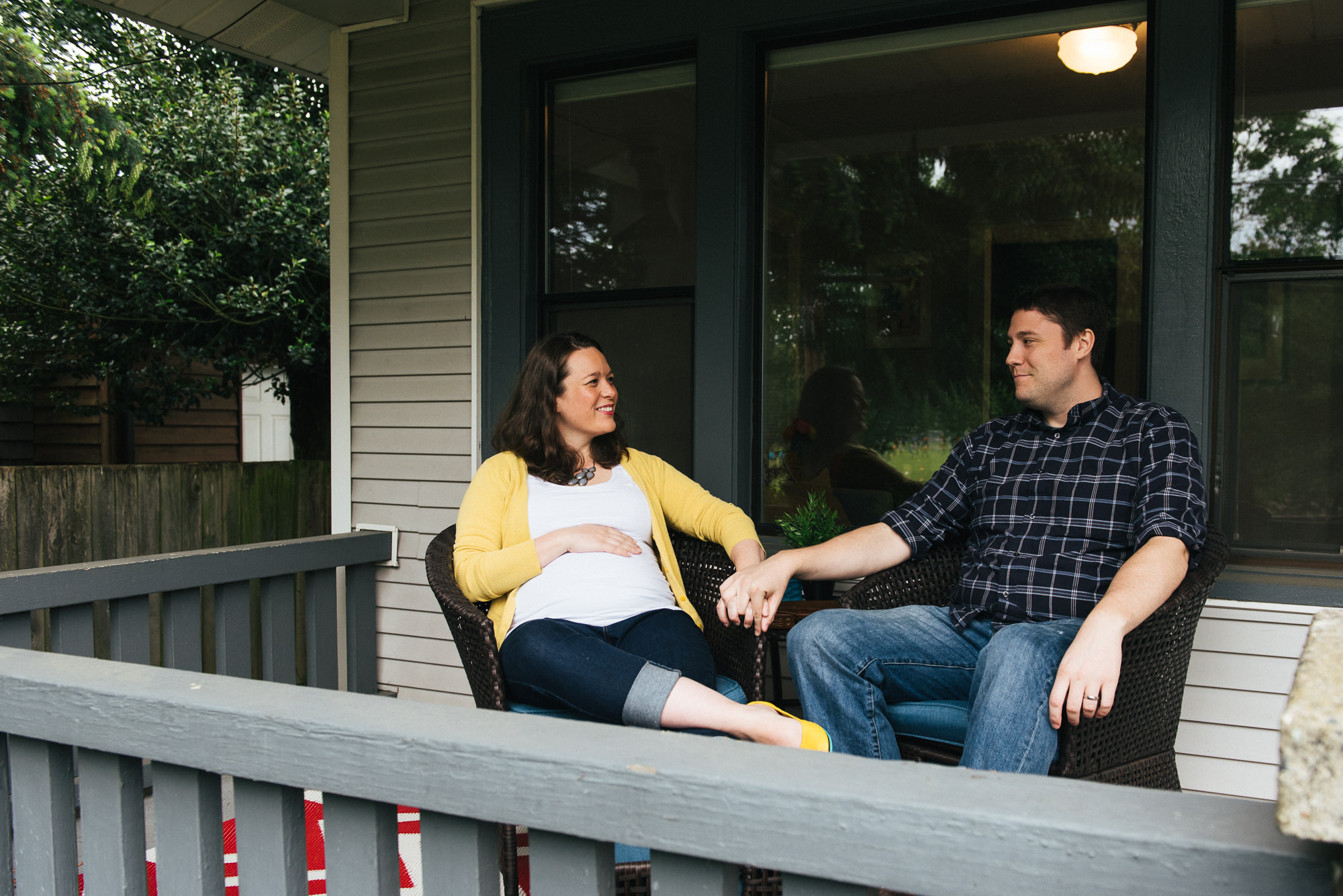 Expecting wife sitting on porch with husband