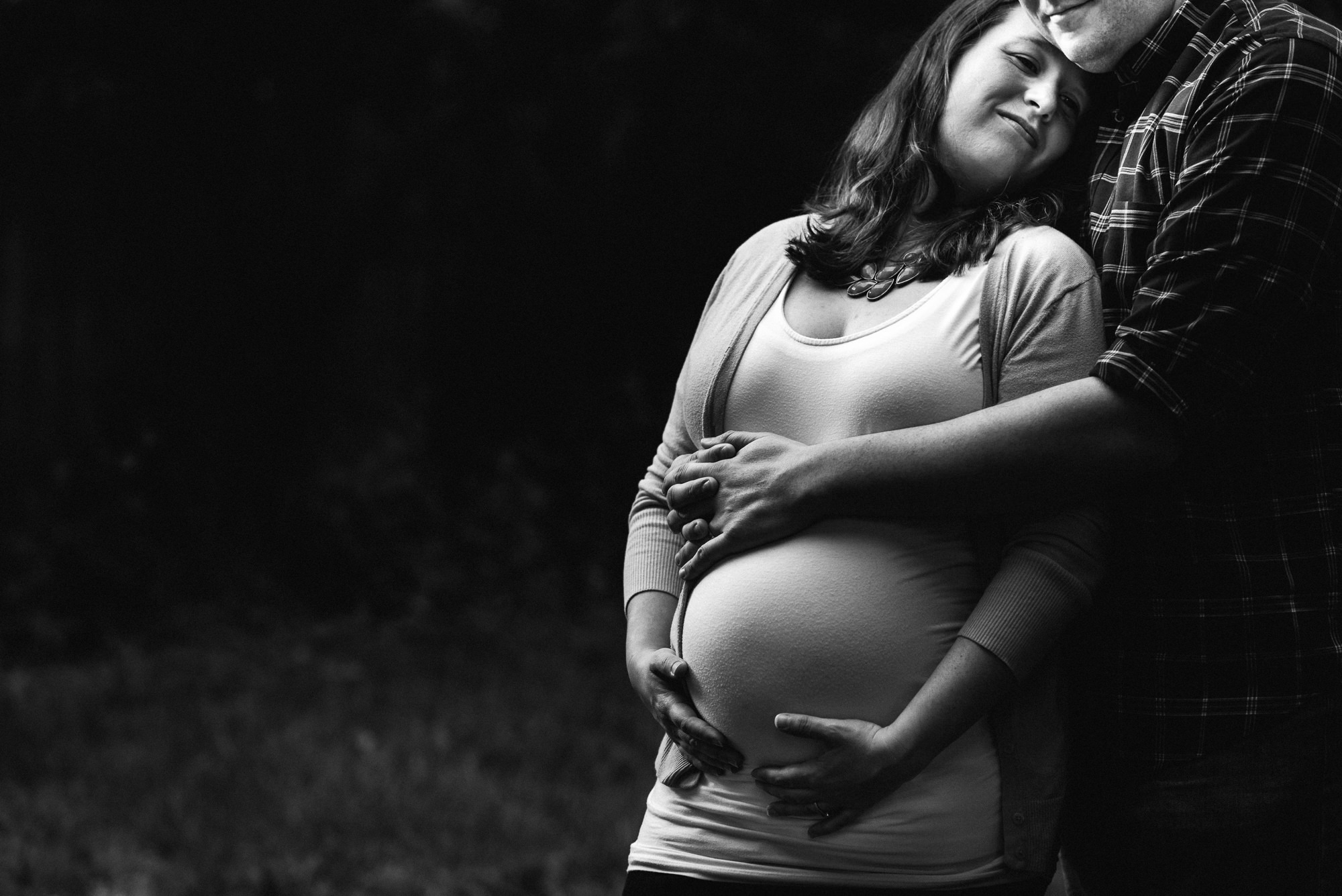 black and white photo of pregnant woman with spouse