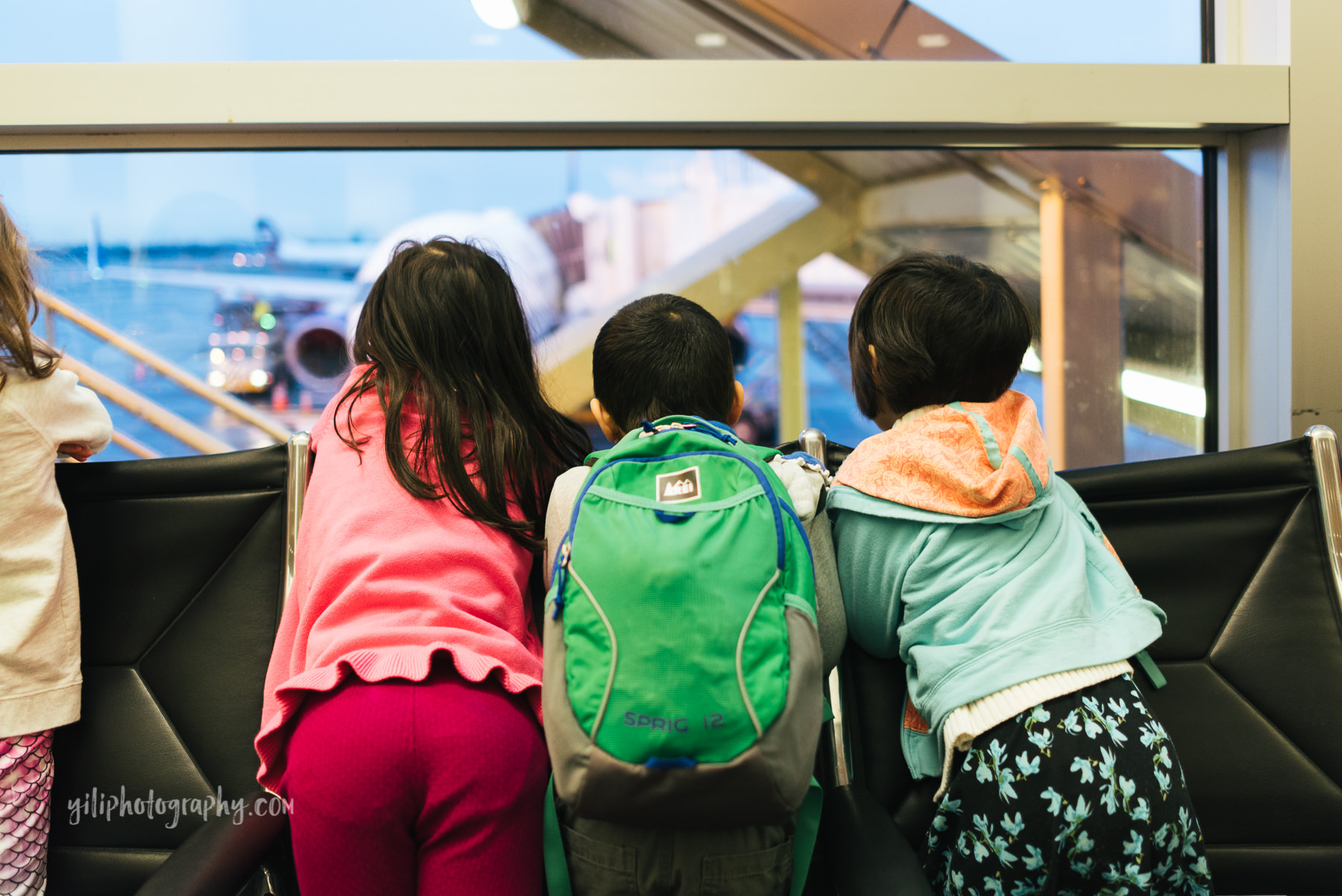 kids looking out window at airport