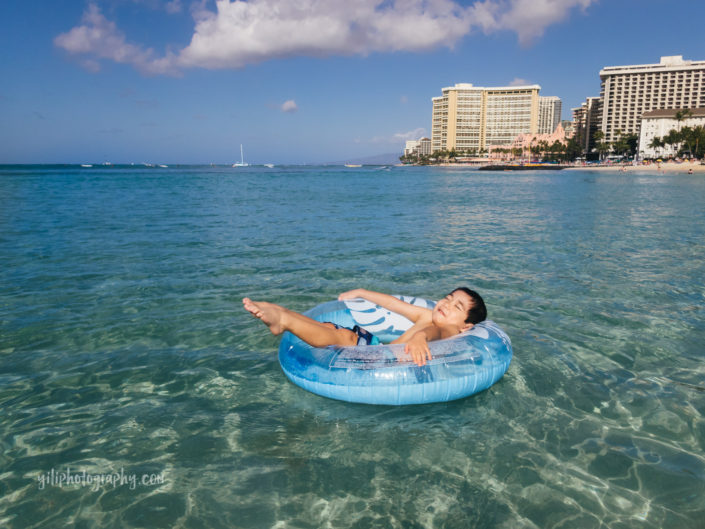 boy in inner tube at waikiki beach