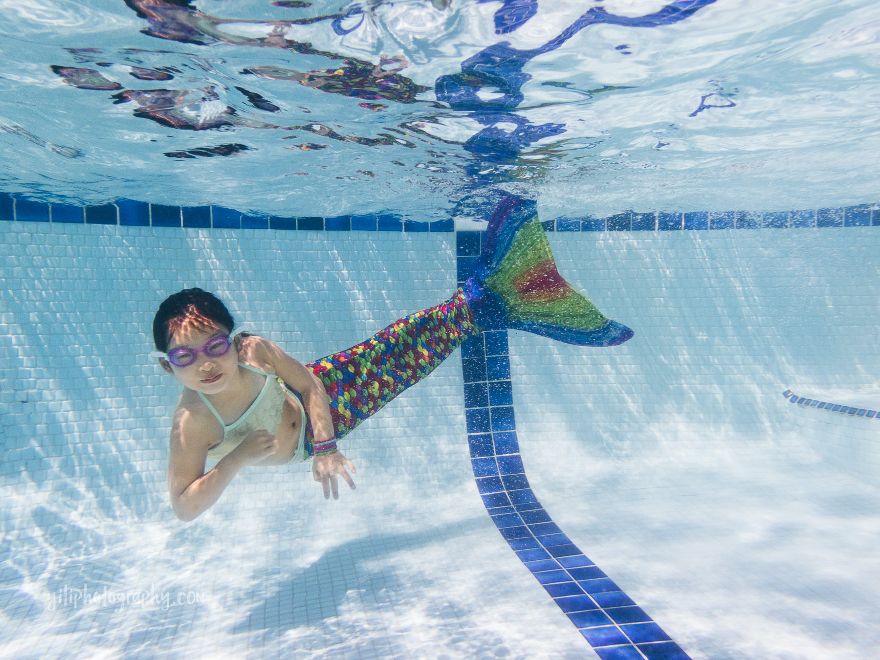girl posing underwater in mermaid tail