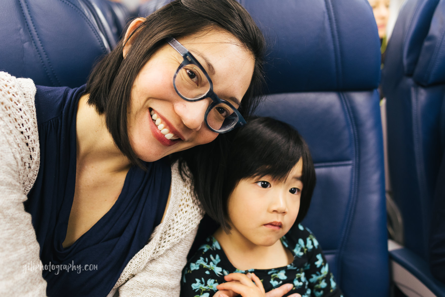 mom and daughter on airplane together