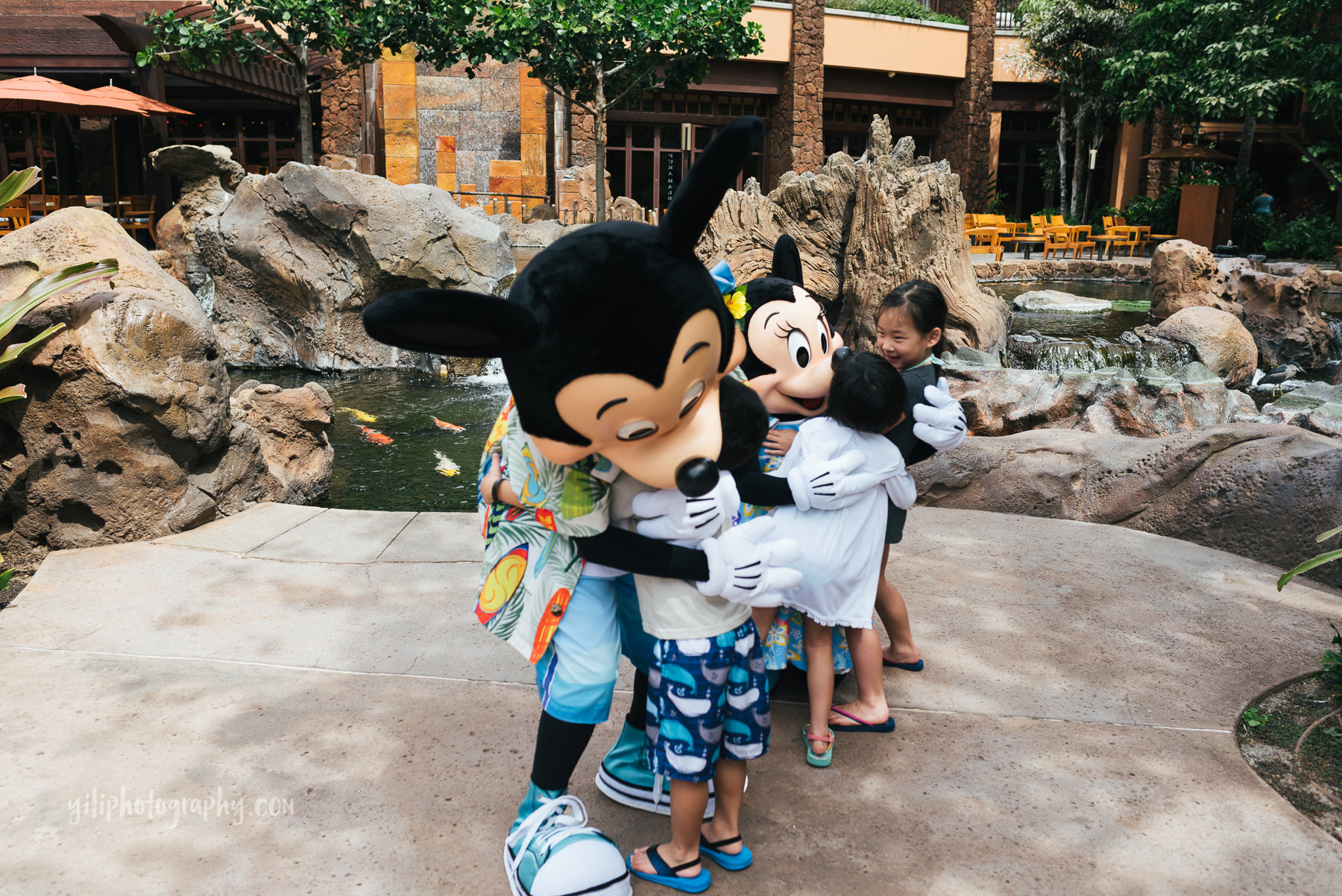 children hugging mickey and minnie mouse at aulani