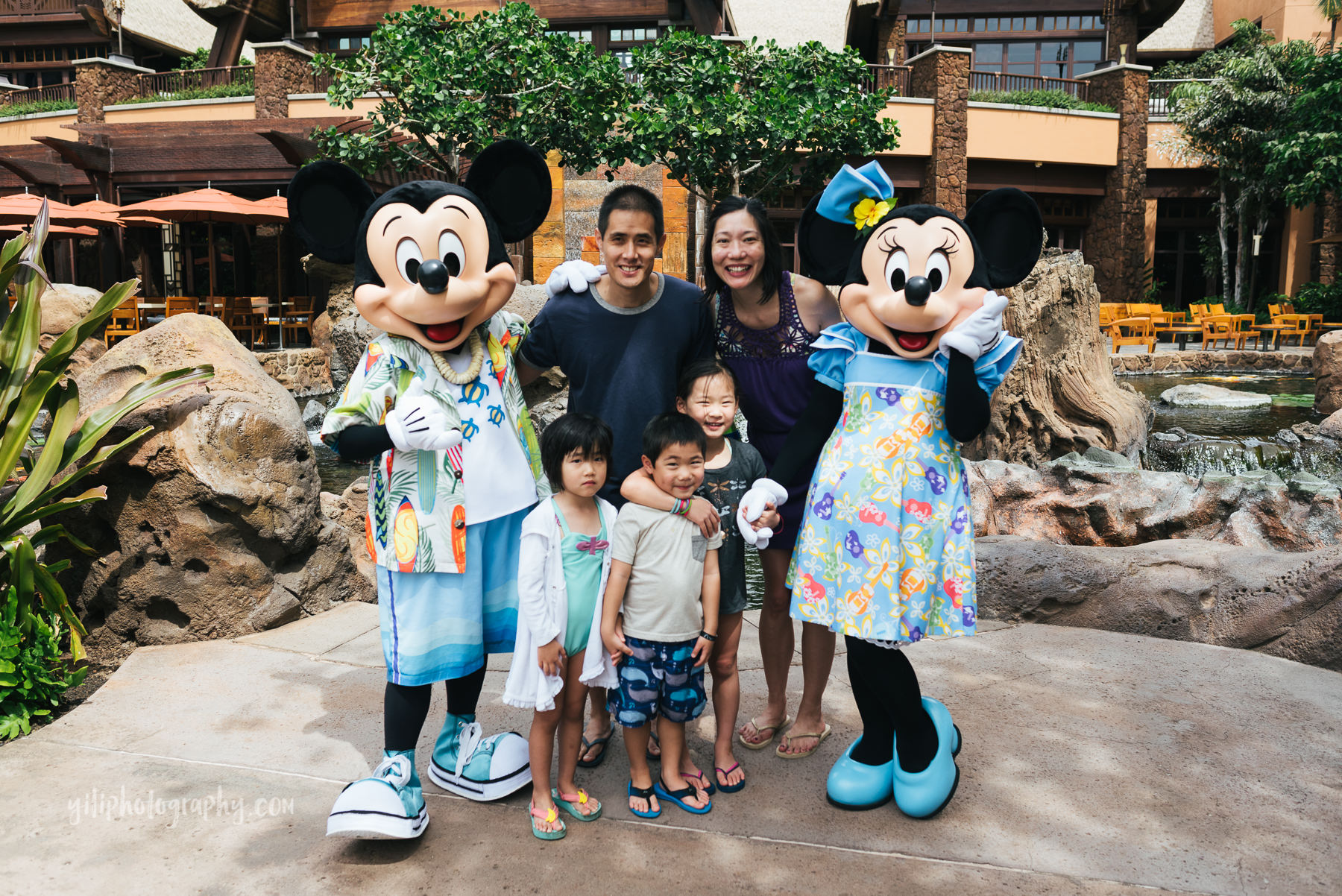 family posing with mickey and minnie at disney aulani