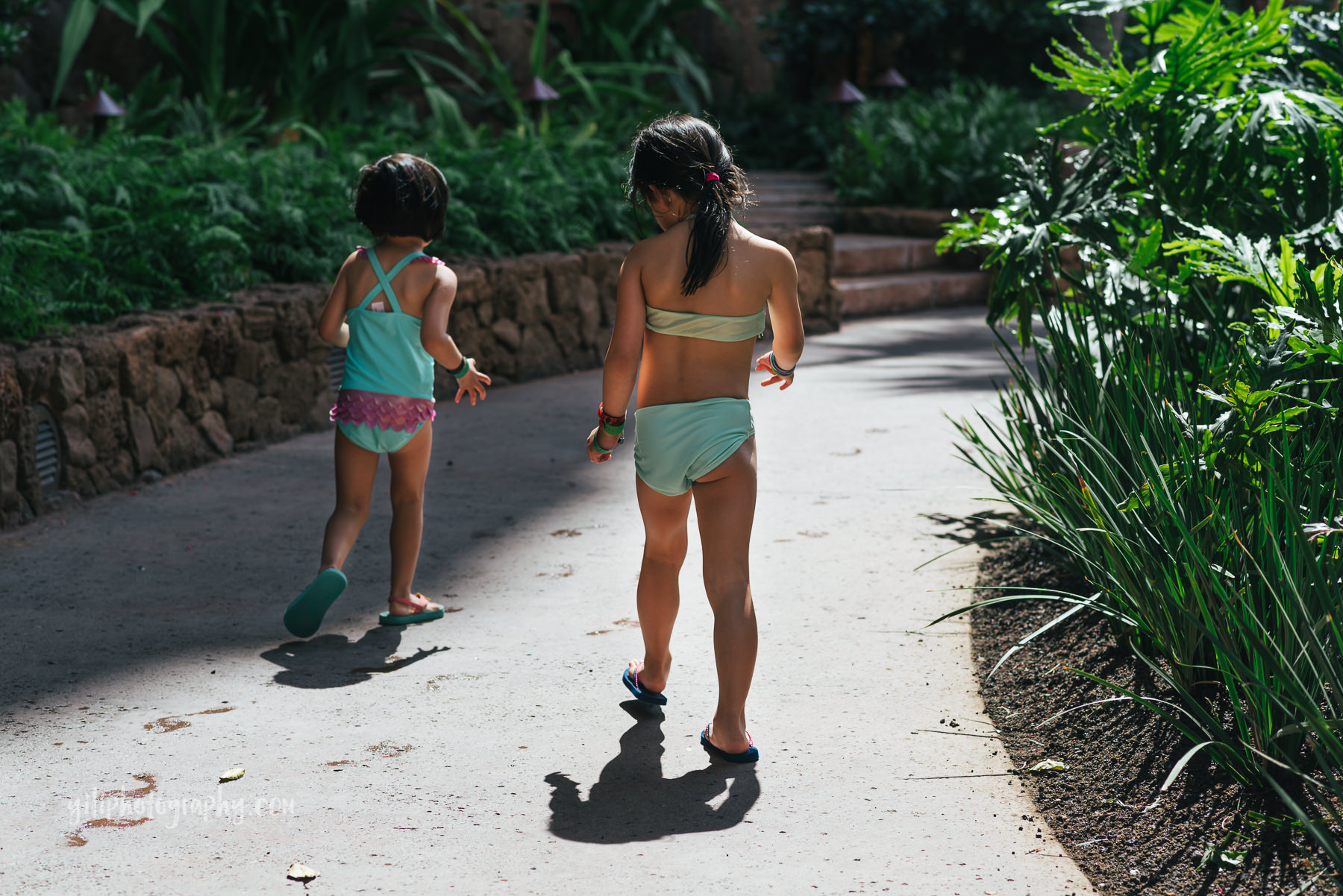 two girls walking along path in swimsuits