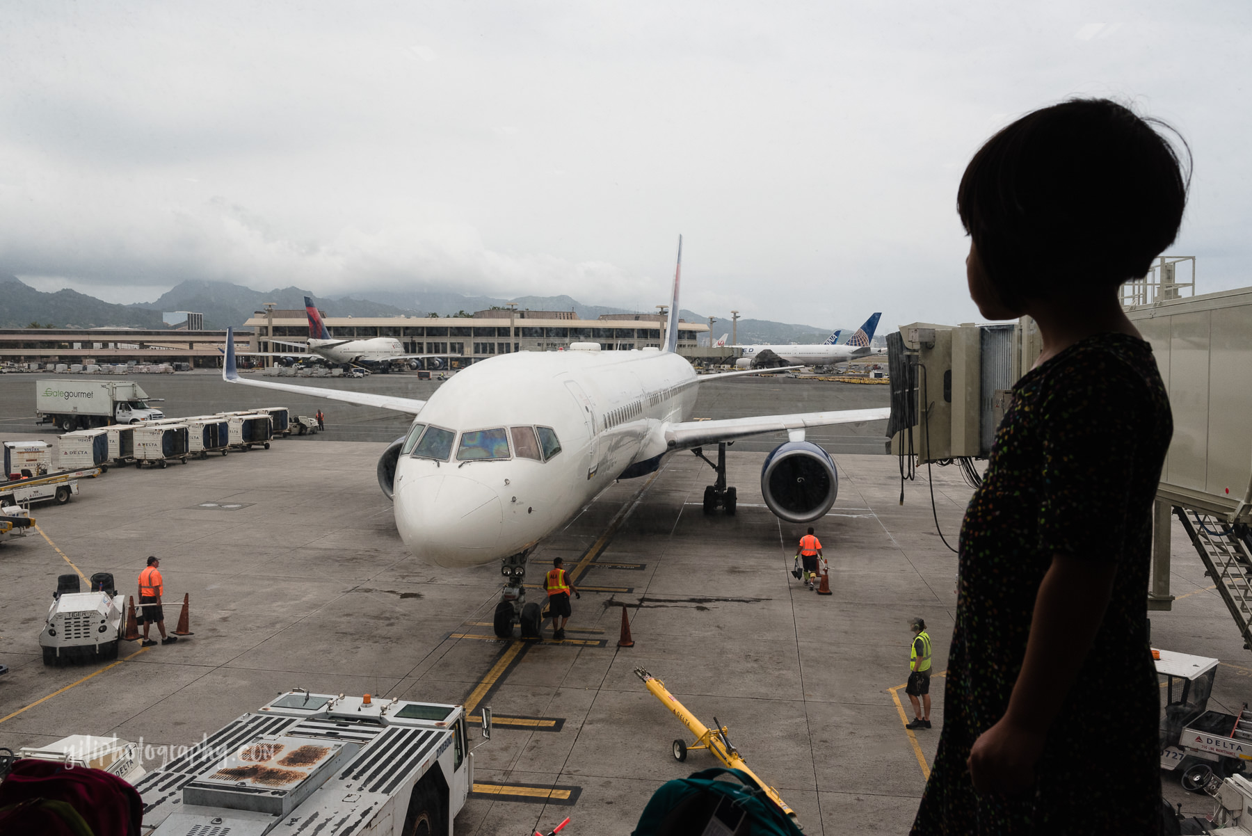 little girl looking out at airplanes at airport