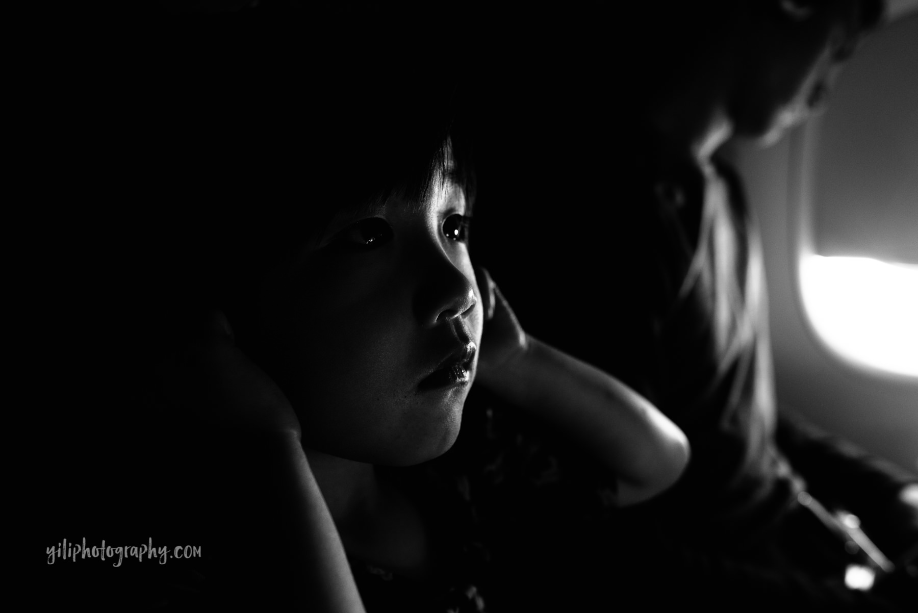 little girl on airplane in black and white