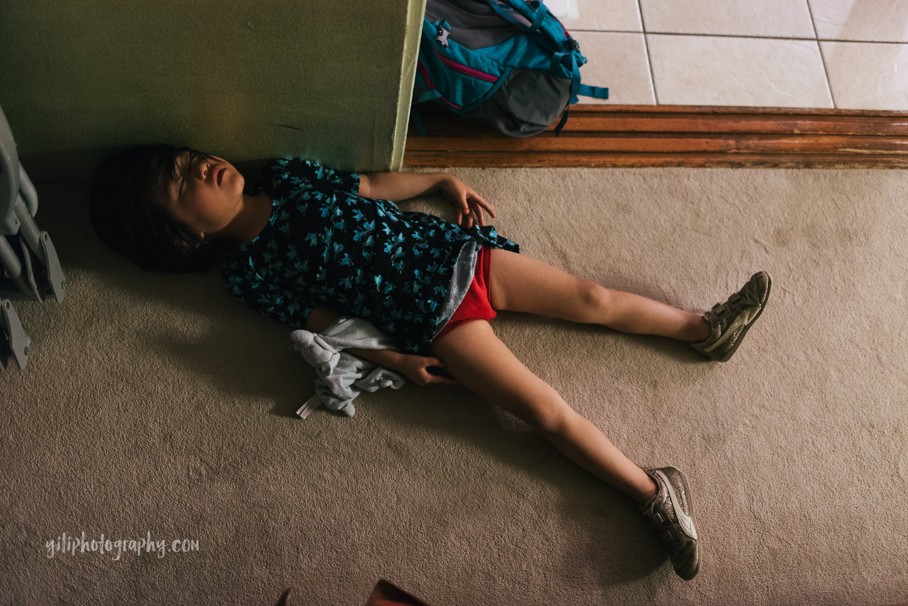 little girl asleep on floor of hotel