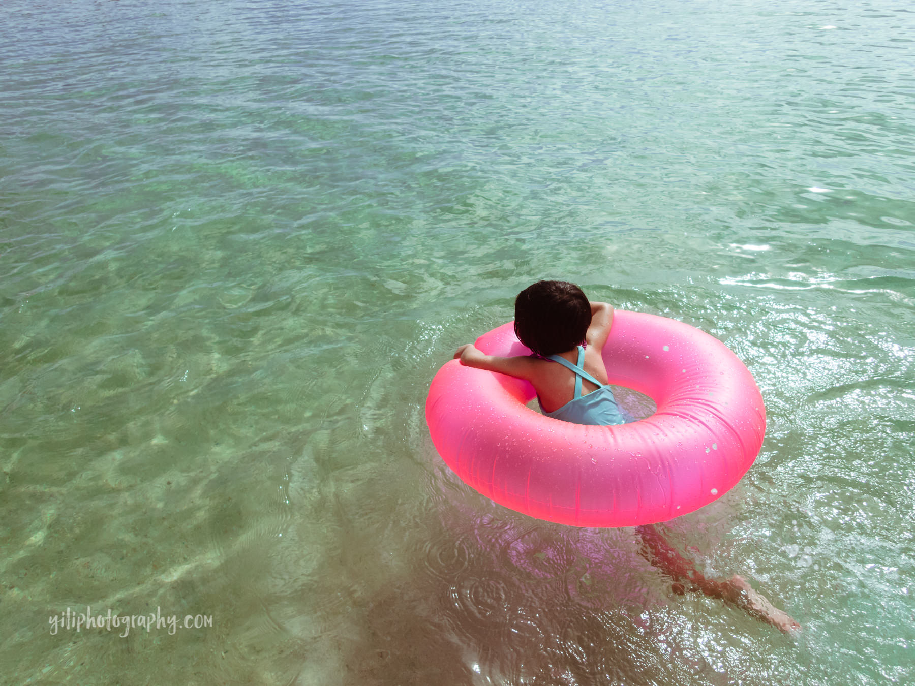 toddler in inner tube at beach