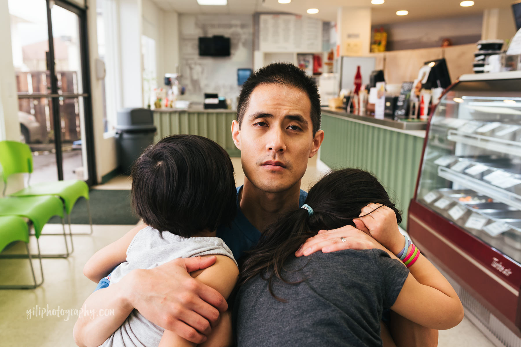tired father hugging two daughters