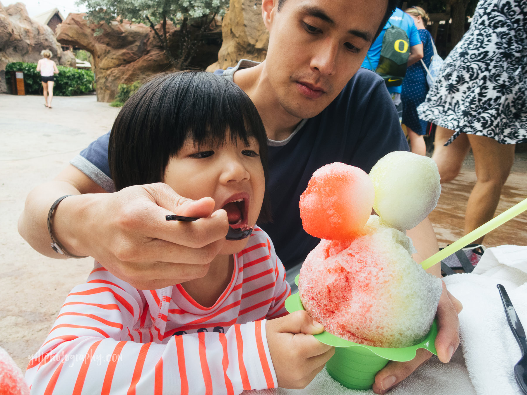 father feeding little girl shave ice