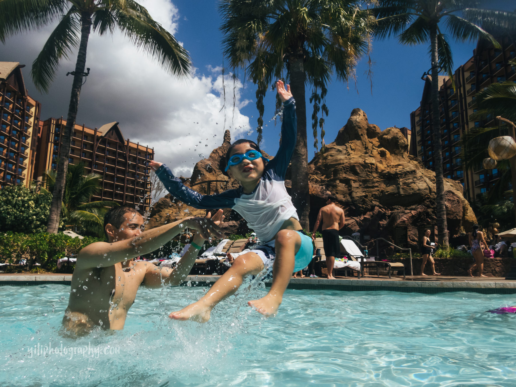 dad in pool throwing son out of water