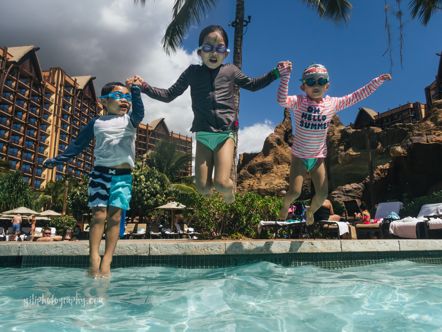 three siblings jumping into Aulani pool together