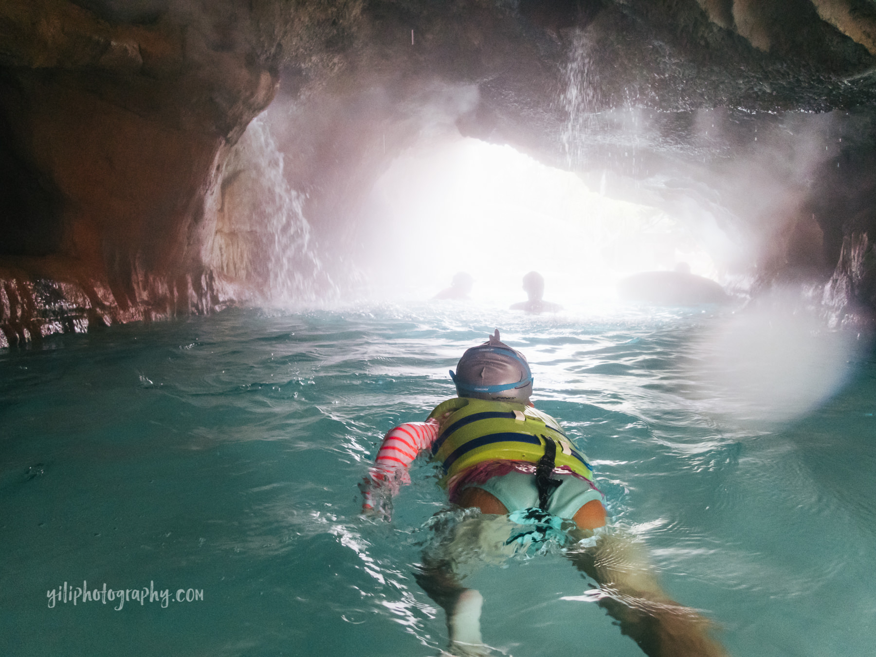 little girl swimming through lazy river cave