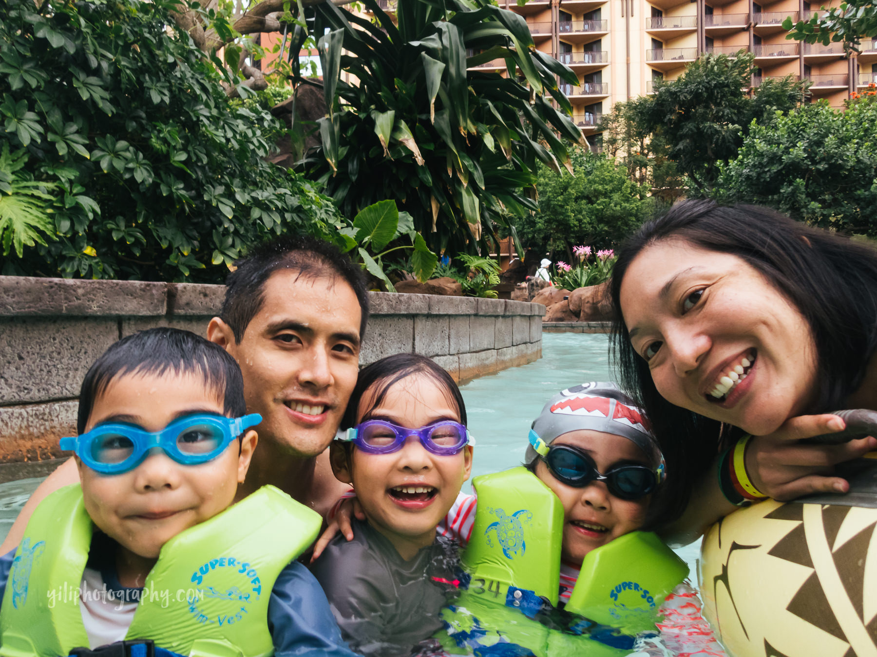 family of five in lazy river at Aulani