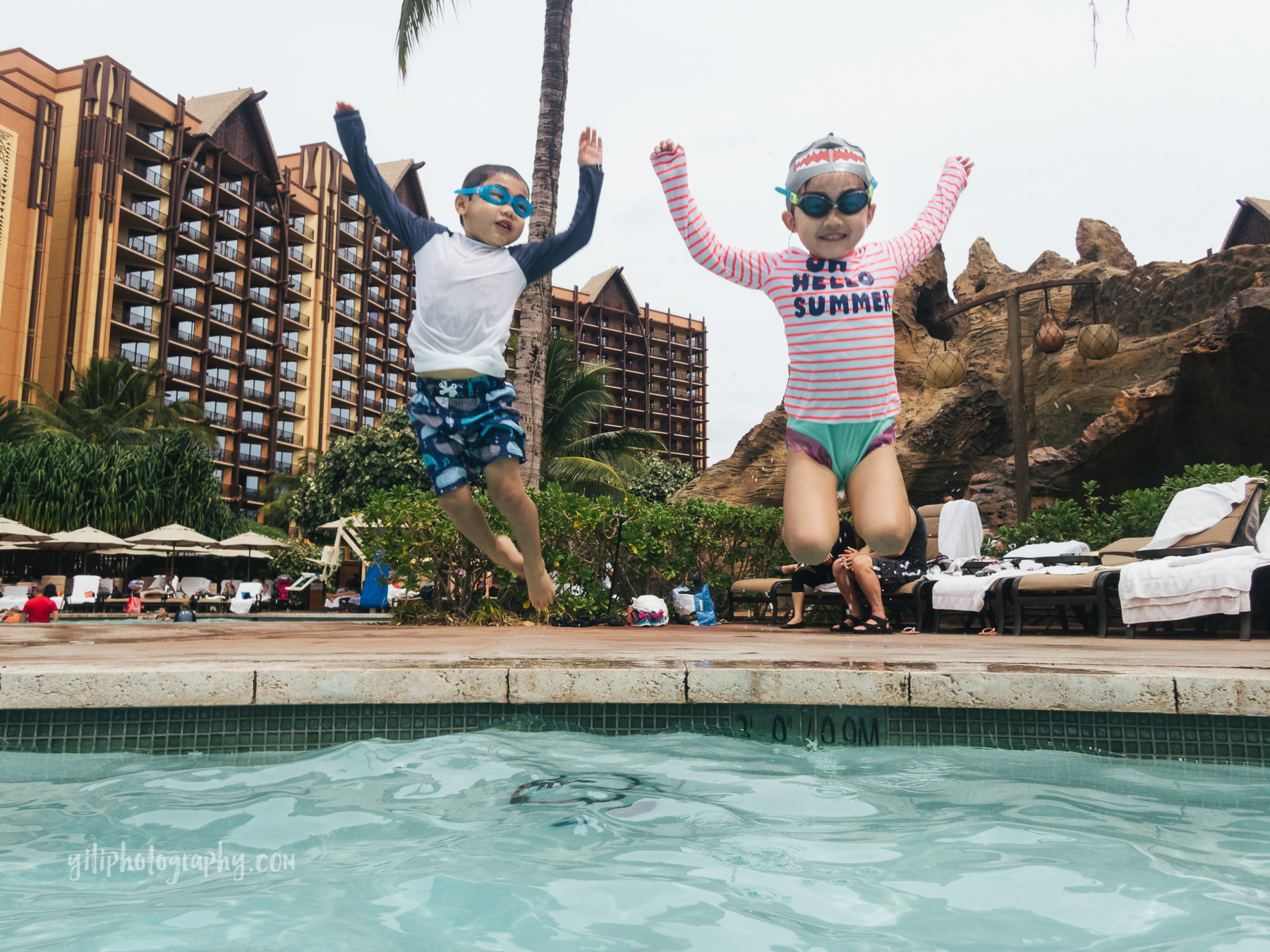 fraternal twins jumping into pool together