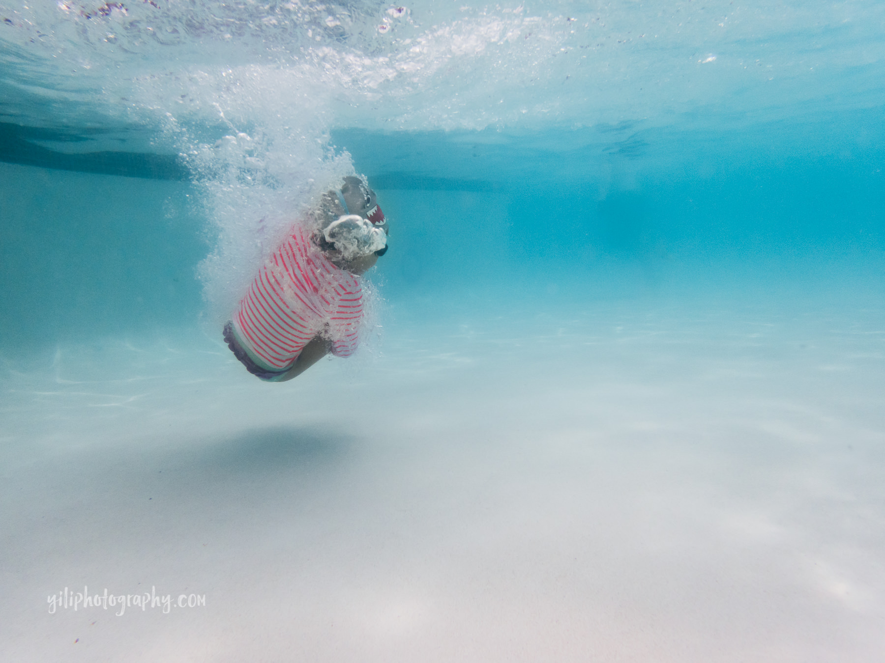 underwater photo of little girl in cannonball