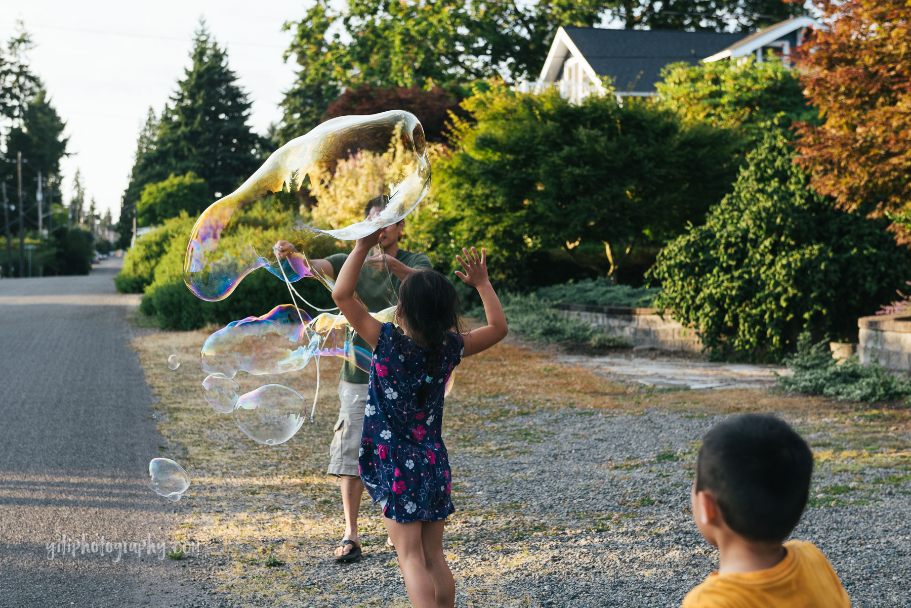 kids running towards dad making giant bubble