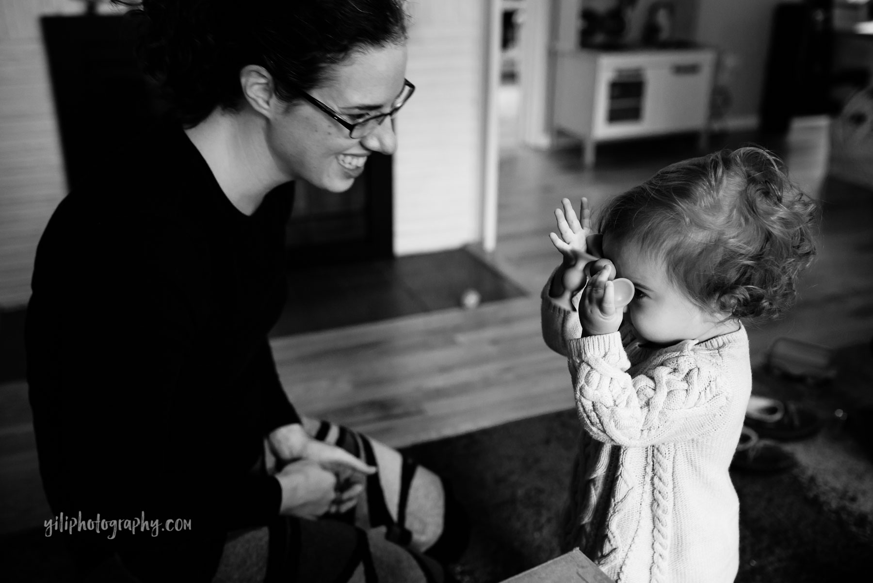 Toddler girl playing peek a boo with mom