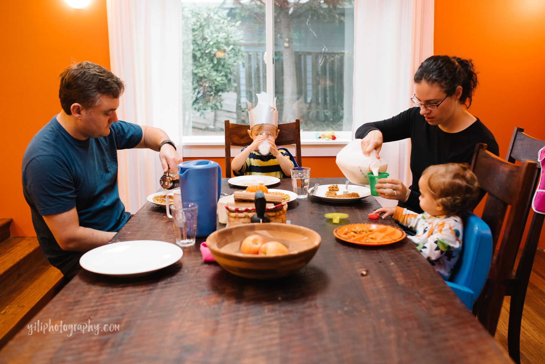 Family of four eating breakfast together at dining table