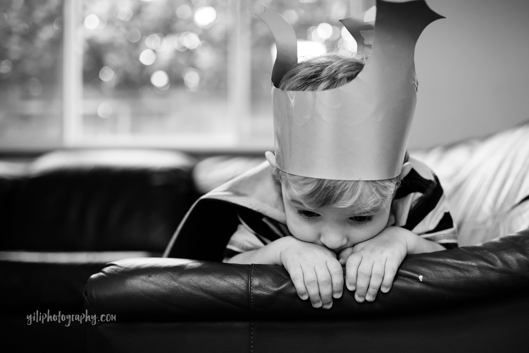 Toddler boy in homemade crown at home