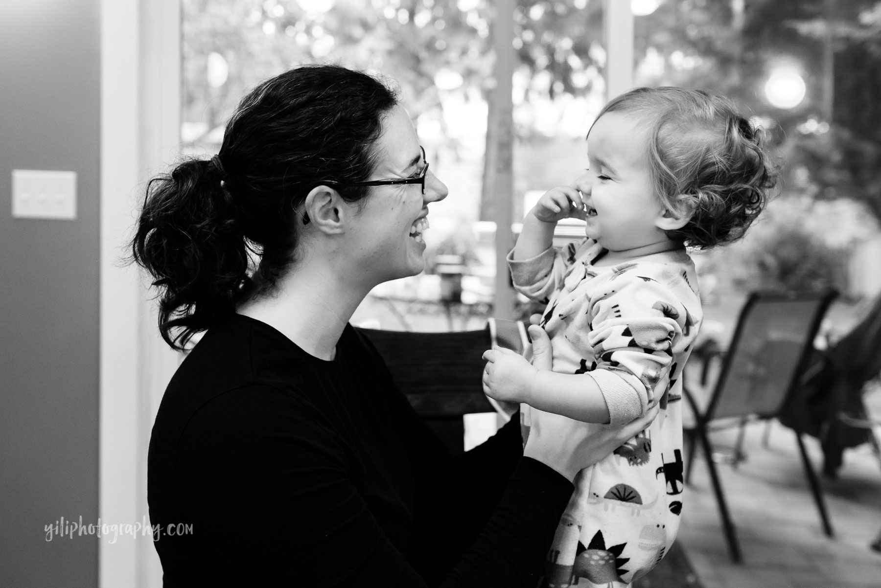 Mom smiling and laughing with toddler girl at home