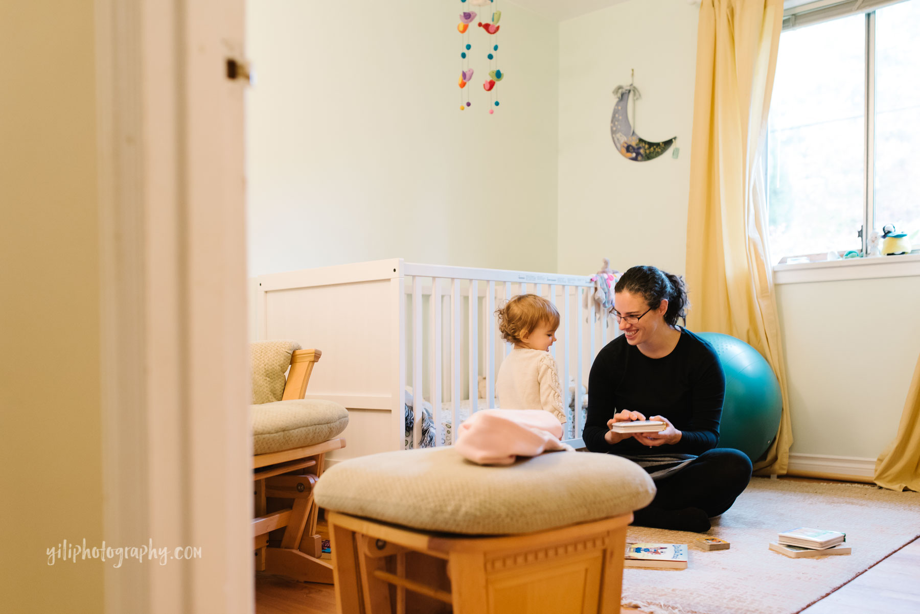 Mom reading with toddler daughter in nursery