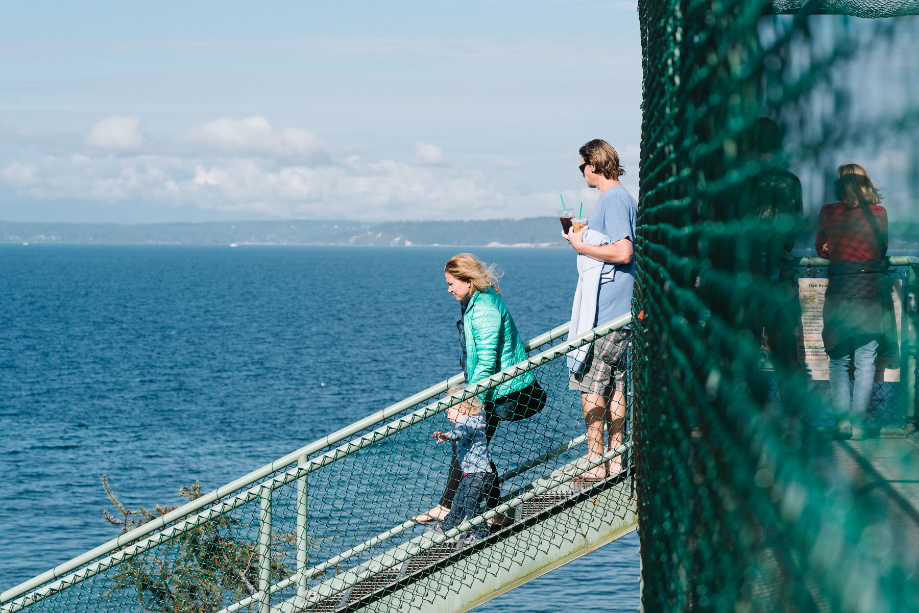 Family walking down train trestle bridge at Carkeek Park in Seattle