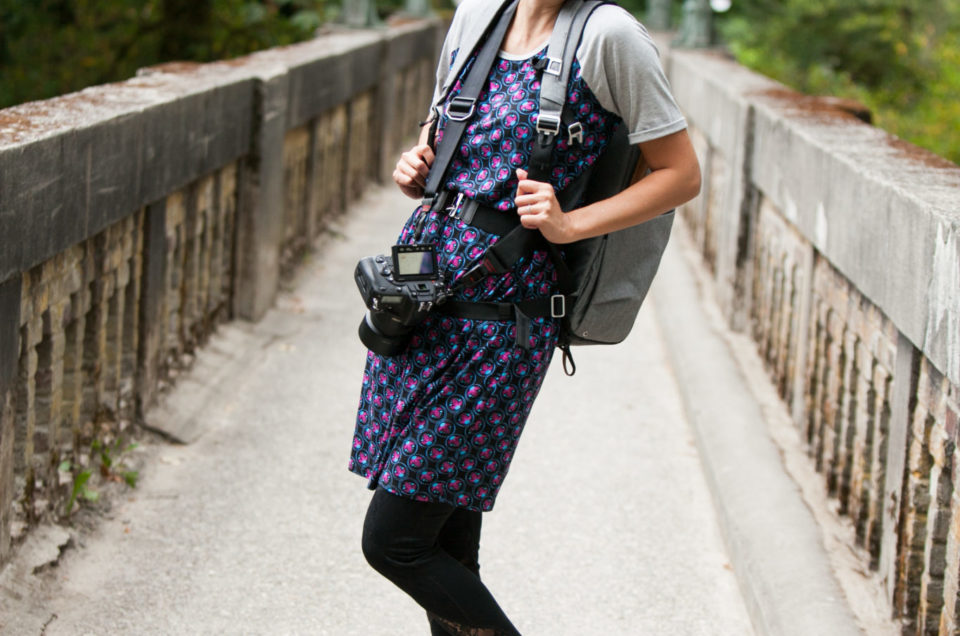 Asian female photographer posing and smiling with gear