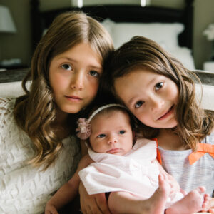 two older sisters with newborn baby sister