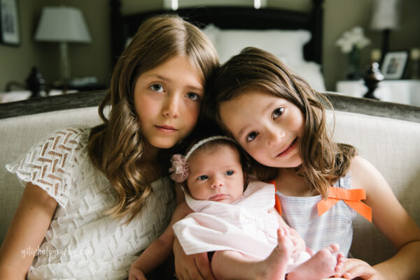 two older sisters with newborn baby sister