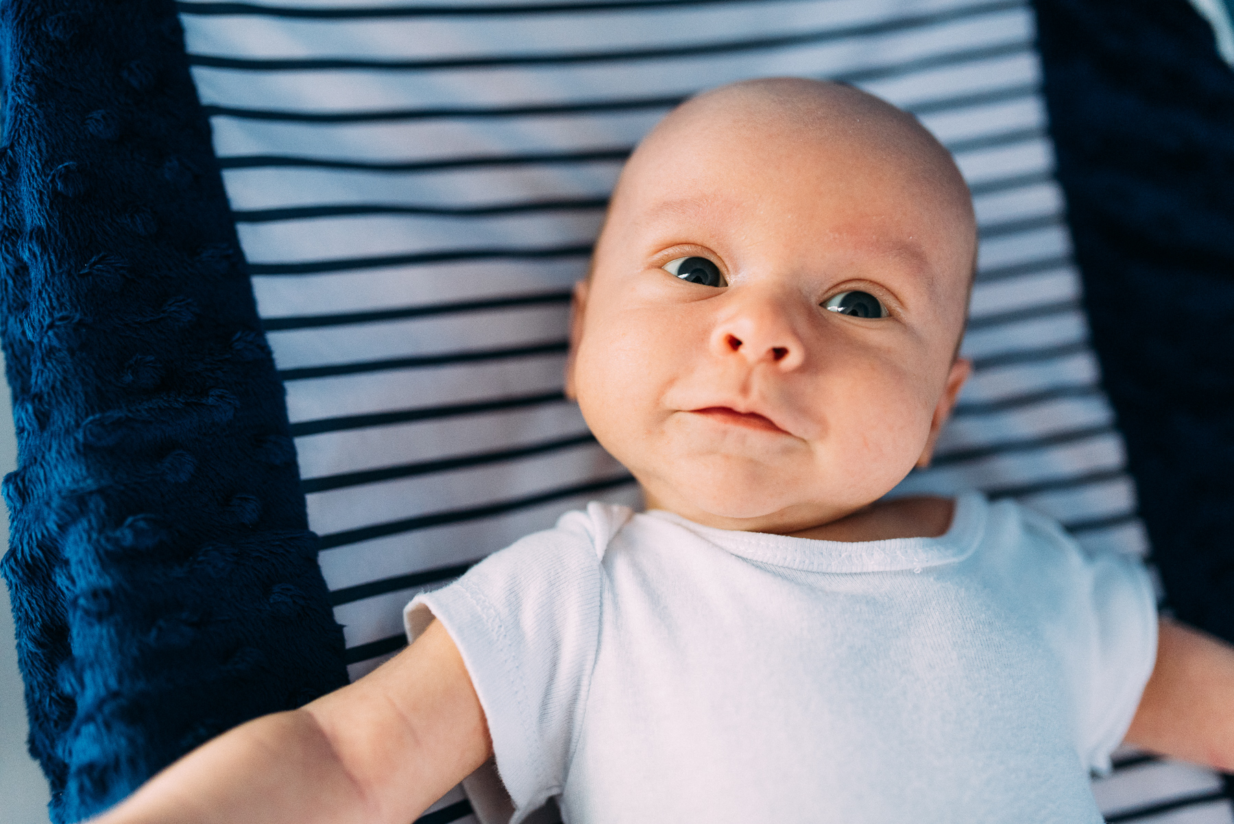 newborn baby boy smiling on changing table