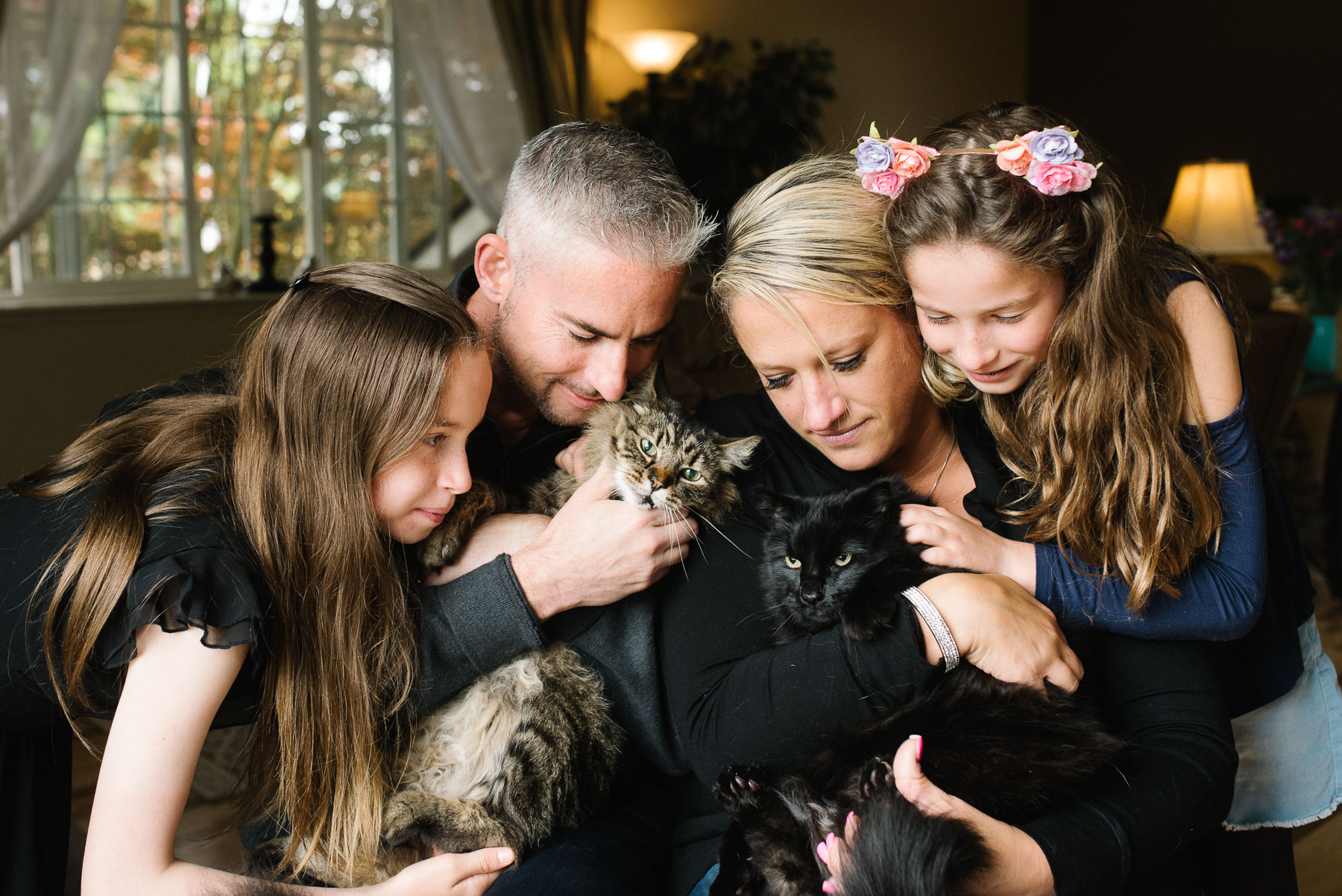 family pets their two cats in living room