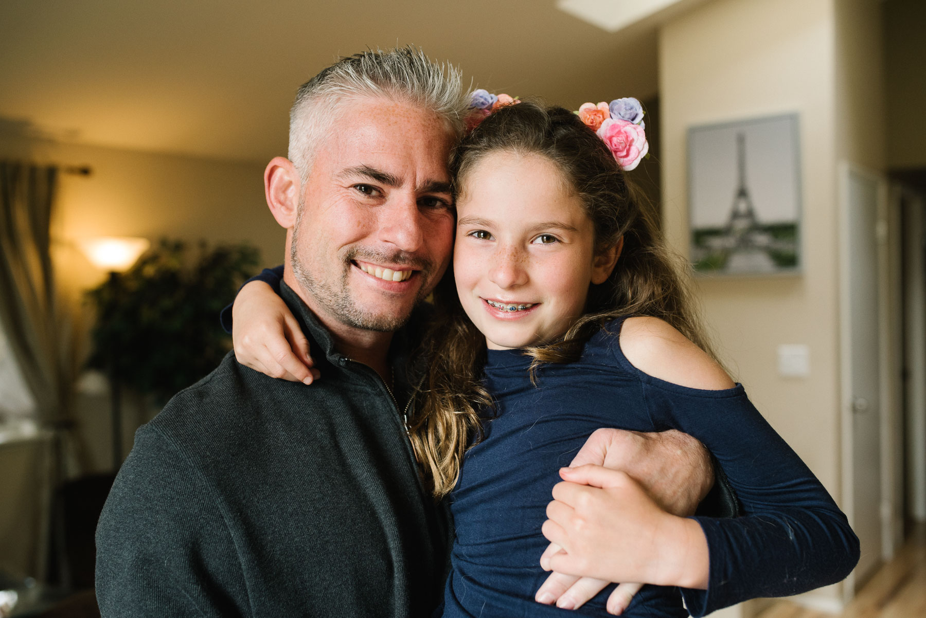 Dad with elementary aged daughter hugging in living room