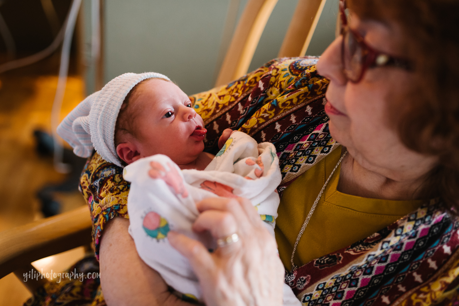newborn baby girl sticks tongue out at grandmother