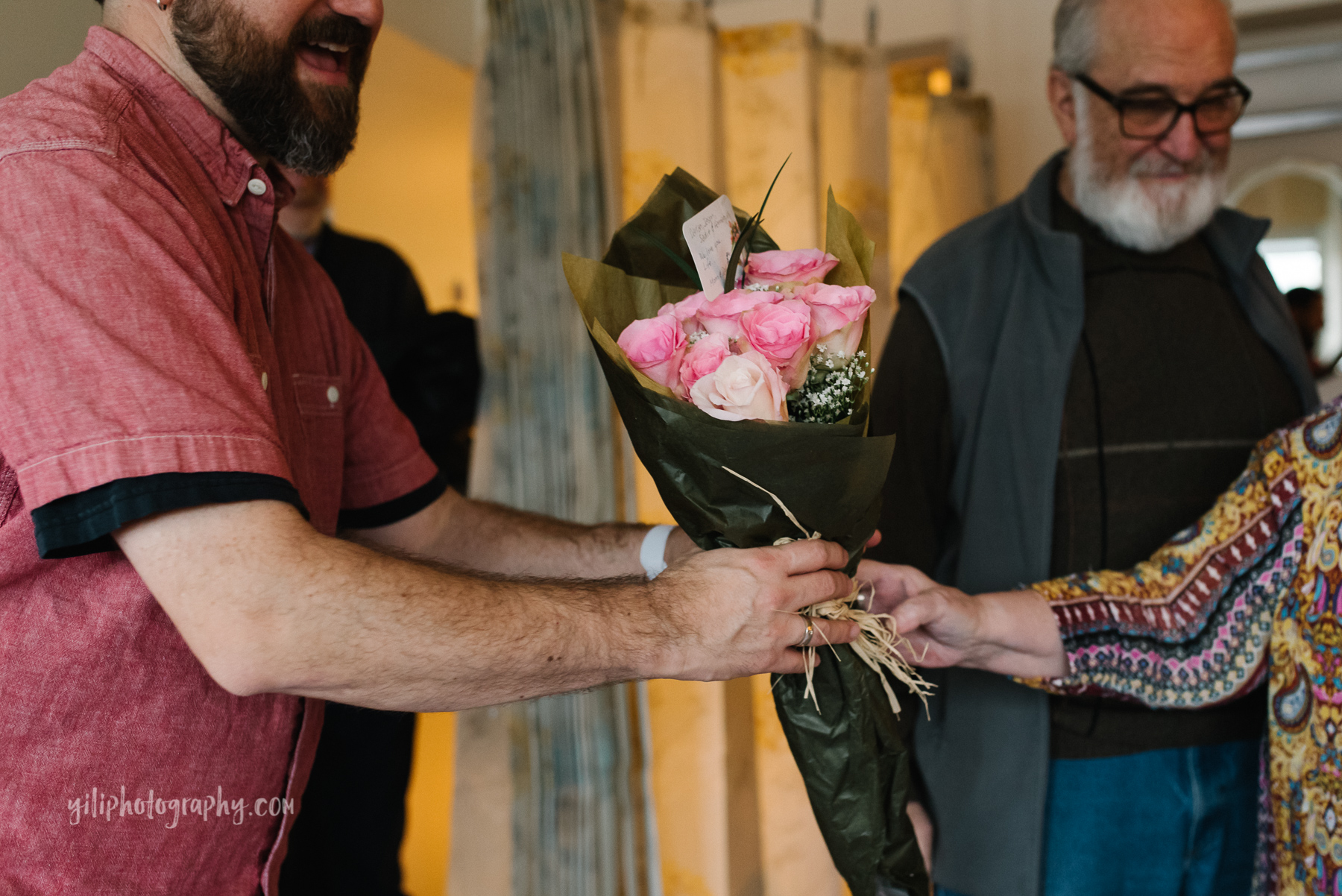 bouquet of pink roses being handed to new dad in hospital room