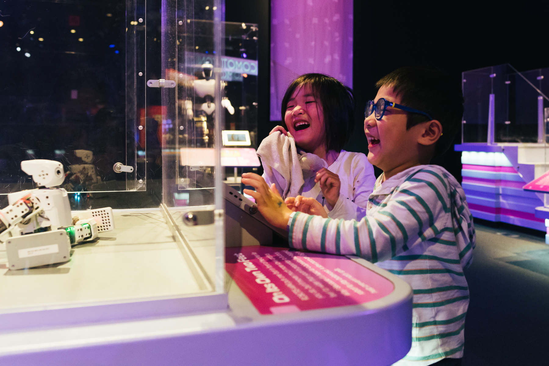 twins laughing at robot museum exhibit