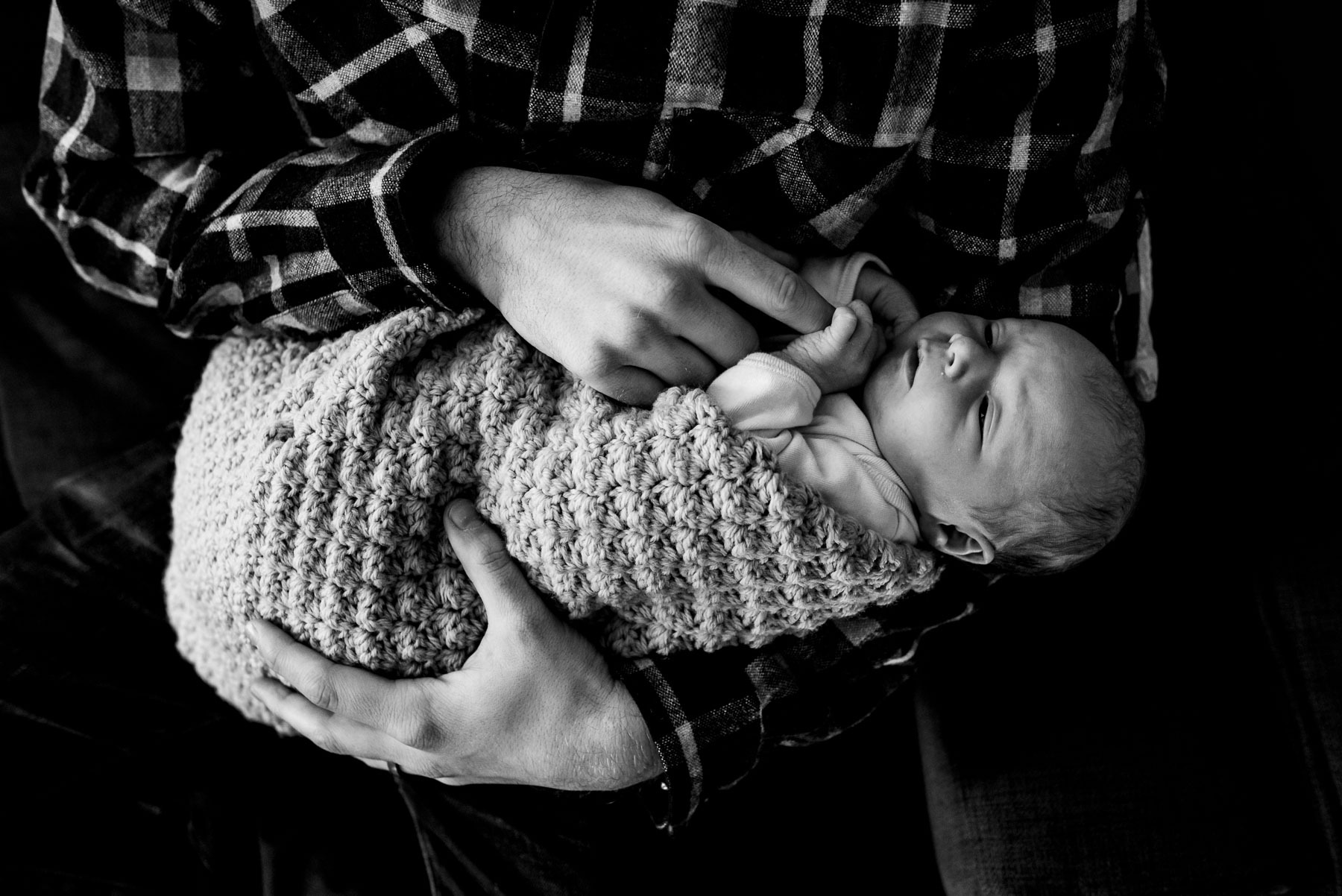 close up of dad holding newborn baby