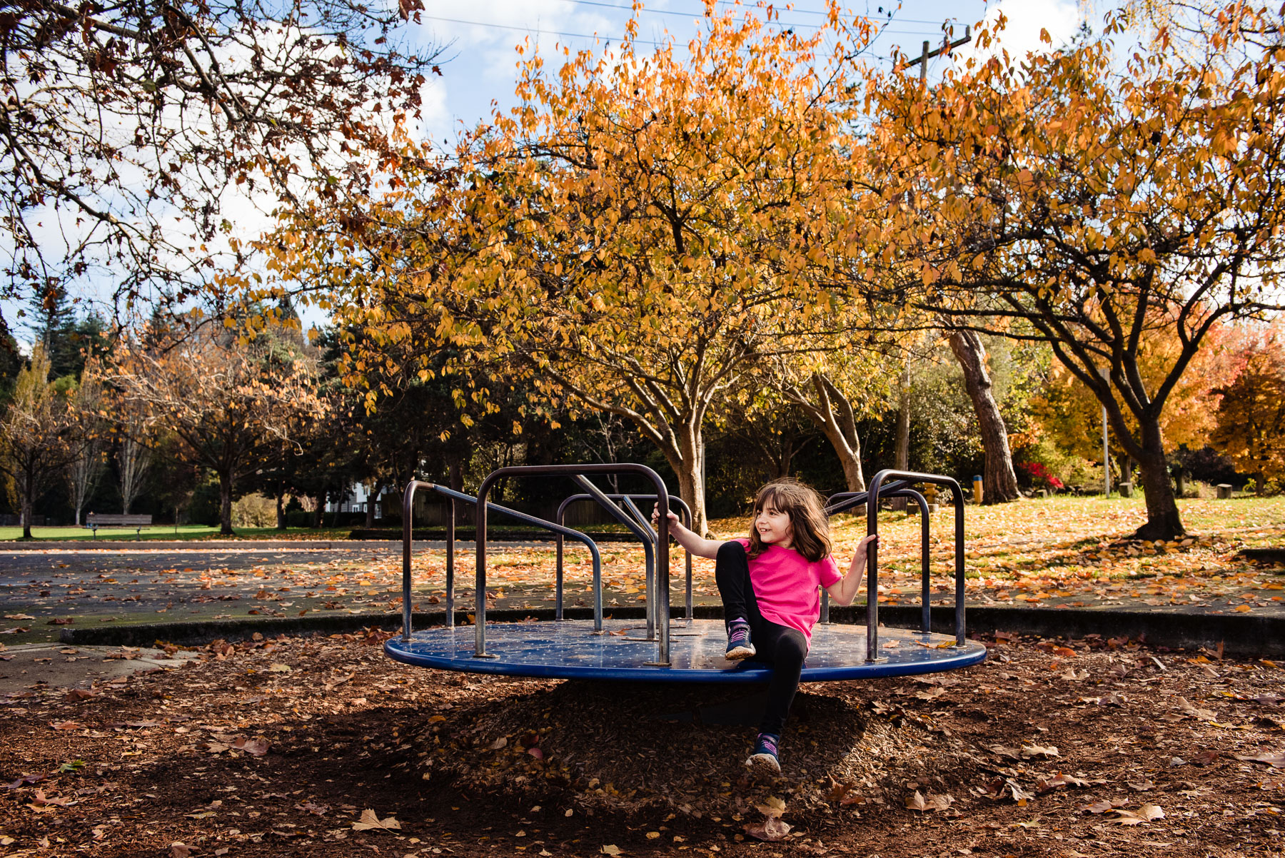 young girl on playground merry go round