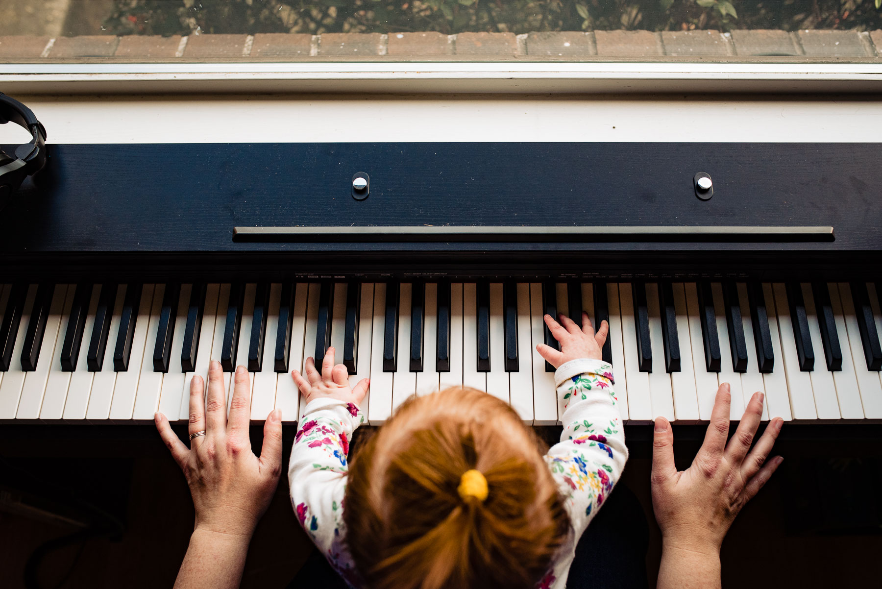 top down photo of mom playing piano with baby