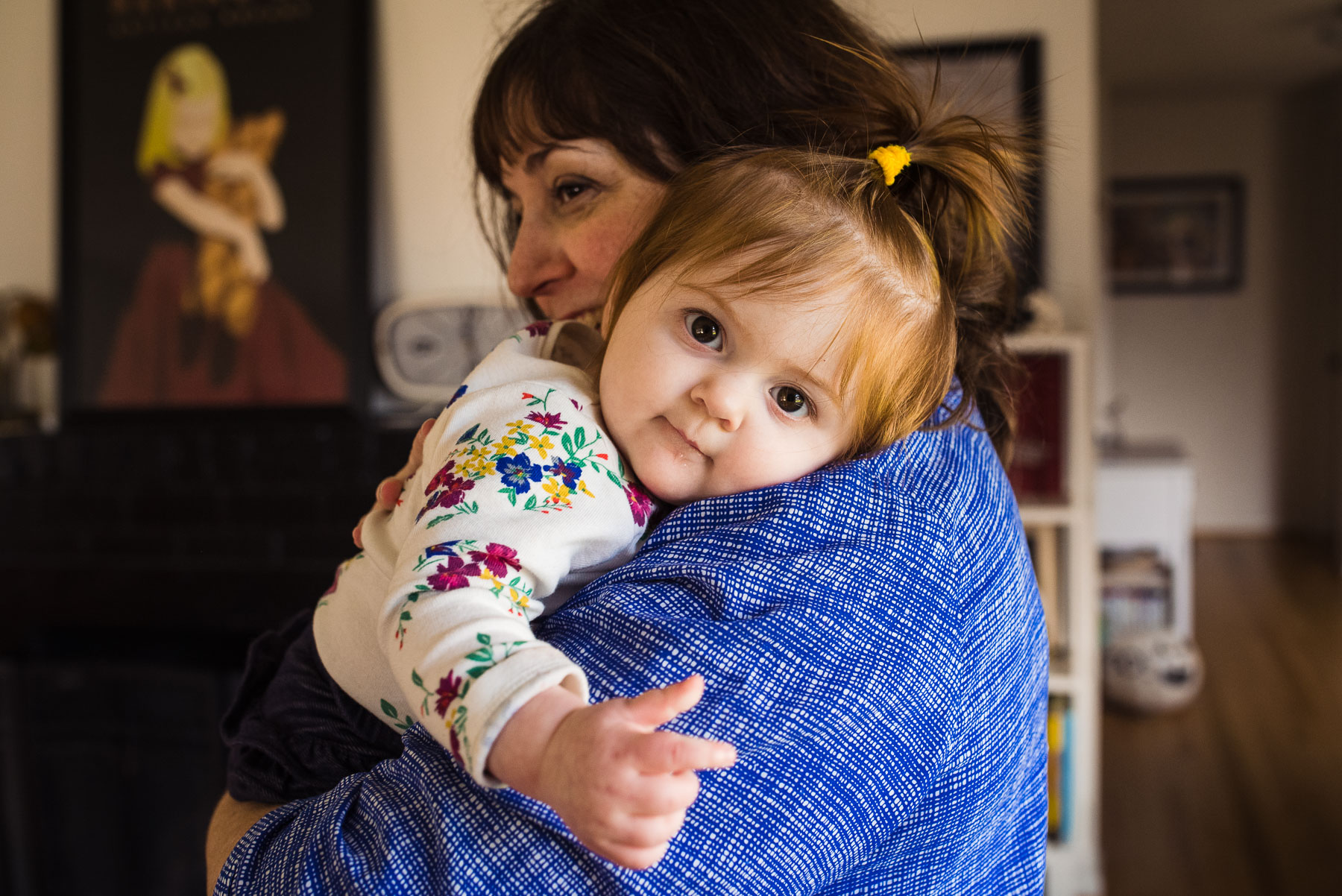 mom holding baby on her shoulder at home