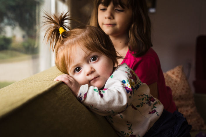 sister and baby together on couch