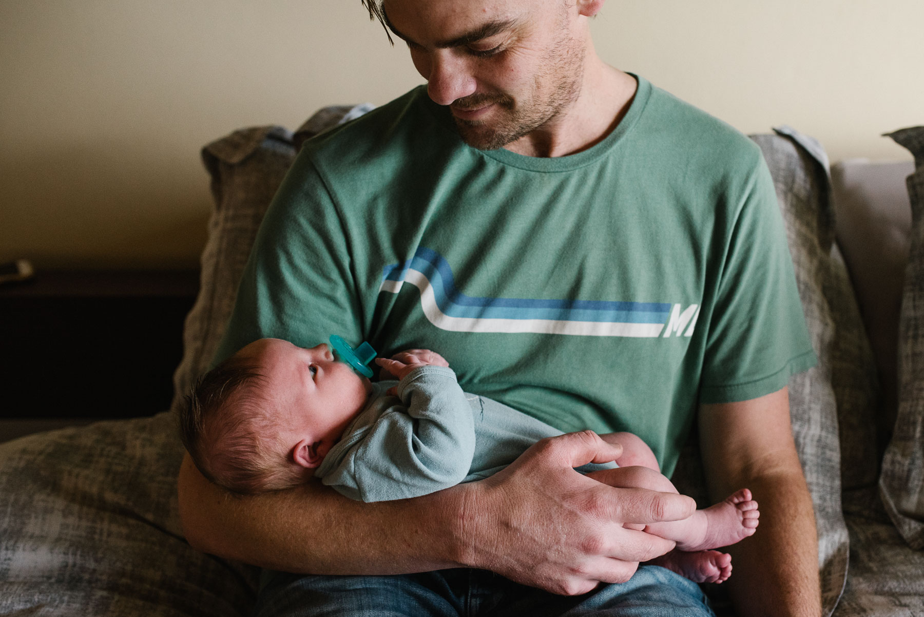 dad smiling holding newborn baby