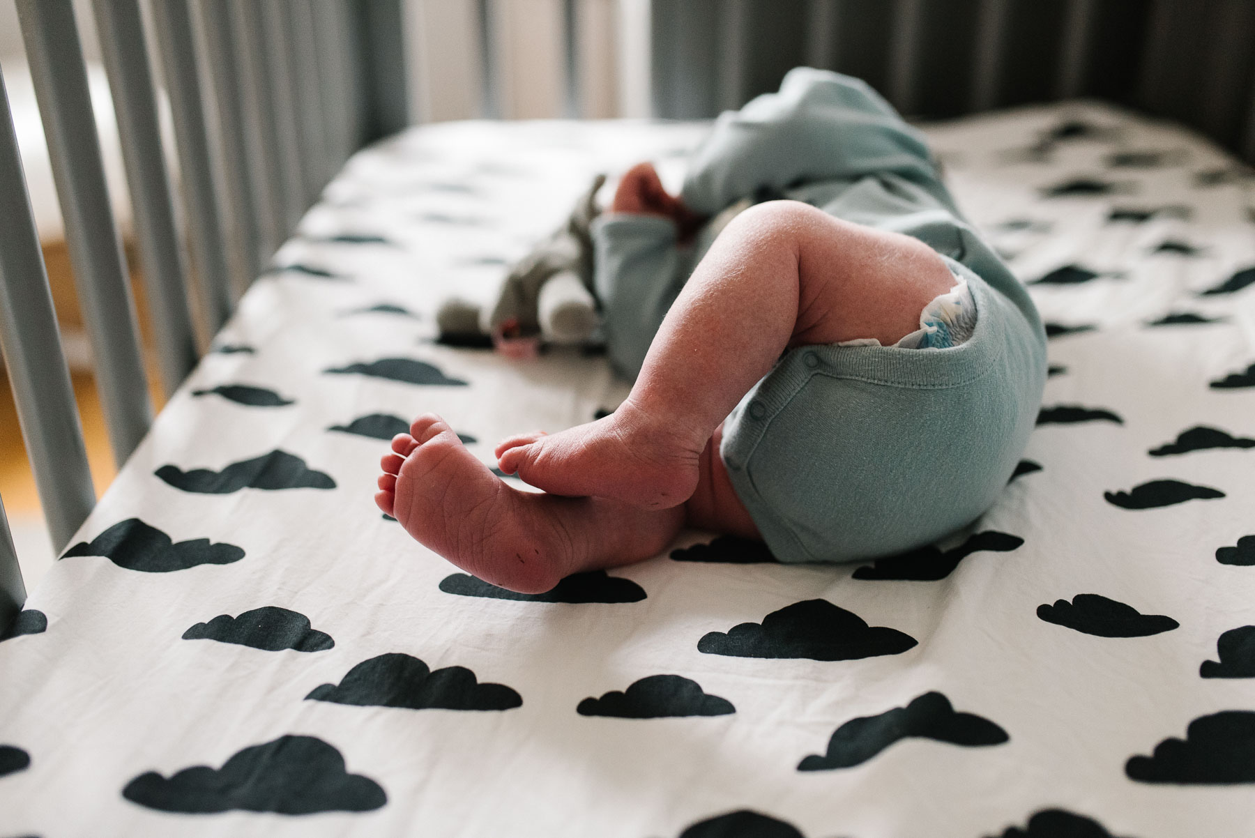 newborn baby thighs and feet in crib