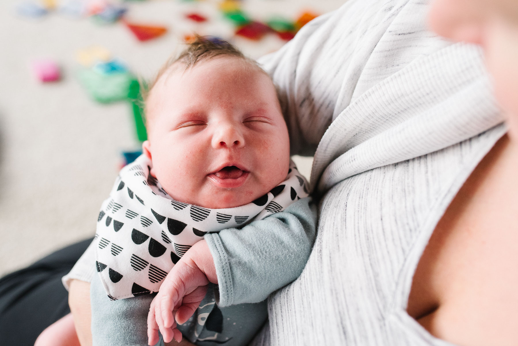 newborn baby boy sleeping in mom's arms